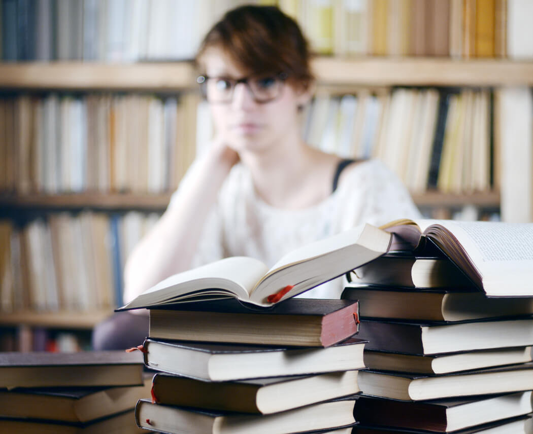 Angehende Notarin hinter Bücherstapeln