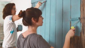 Frauen streichen Wand / Kunden zurückholen