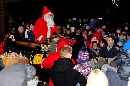 Der Nikolaus kommt zum Weihnachtsmarkt und verteilt kostenlos Tüten an die Kinder